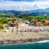 Spiaggia affollata con ombrelloni e vista panoramica.