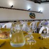 Sala da pranzo con tavoli apparecchiati e sedie bianche.