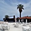 Spazio aperto con tavoli bianchi e un palco.