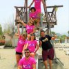 Gruppo di persone in magliette rosa su una torre di legno.