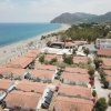 Spiaggia con ombrelloni e edifici costieri.