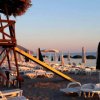 Spiaggia con lettini e ombrelloni al tramonto.