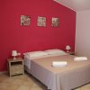Camera con parete rosa, letto matrimoniale e letti a castello.