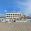 Hotel fronte mare con spiaggia e lettini blu.