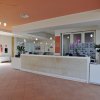 Reception moderna con piante e luce naturale.