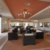 Ampia hall con divani e soffitto arancione.