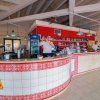 Un bar moderno con un bancone curvo e arredamento rosso.