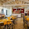 Ristorante con tavoli apparecchiati e soffitto con travi a vista.
