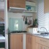 Cucina moderna con fornelli e lavandino, mobili chiari.