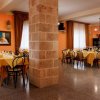 Sala da pranzo con tavoli apparecchiati e pareti color crema.