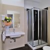 Bagno moderno con doccia, lavandino e specchio.