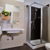 Bagno con lavabo, doccia e vasi di fiori.