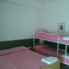 Camera con letto matrimoniale e letto a castello rosa.