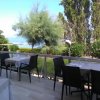 Tavoli all'aperto con vista mare e alberi.