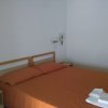 Camera con letto matrimoniale e lenzuola arancioni.