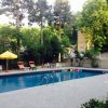 Una piscina circondata da sedie a sdraio e ombrelloni gialli.