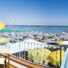 Vista spiaggia con lettini e ombrelloni gialli.