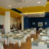 Ristorante con tavoli apparecchiati e soffitto colorato.