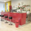 Bancone bar rosso con sgabelli neri e decorazioni.