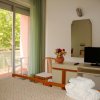 Camera con letto, TV, specchio e balcone.