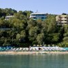 Spiaggia con ombrelloni e alberi verdi sullo sfondo.