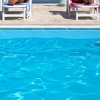 Due persone sulle sdraio vicino a una piscina.