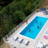 Piscina con persone che nuotano, vista dall'alto.