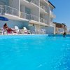 Piscina con persone che nuotano e prendono il sole.