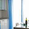 Cucina moderna con tende blu e tavolo apparecchiato.
