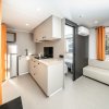 Cucina moderna con arredi neutri e divano bianco.