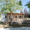 Casa mobile con veranda, alberi intorno.