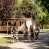 Famiglia in bicicletta su un vialetto alberato.