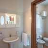 Lavabo con specchio e sanitari in bagno luminoso.