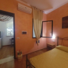 Camera da letto con pareti arancioni, letto matrimoniale, finestra aperta e condizionatore d'aria.