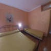 Camera da letto con pareti arancioni, un letto matrimoniale e un letto singolo.