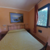Camera da letto con letto matrimoniale, quadro e finestra.