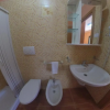 Bagno con doccia, bidet, lavabo e specchio.