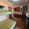 Camera con letto a castello, cucina compatta, pareti arancioni.
