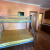 Stanza con letto a castello, piccola TV, cucina in legno.