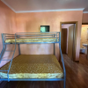 Letto a castello, bagno visibile, cucina in legno sulla destra.