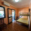 Camera con letto a castello, pareti arancioni, condizionatore e porta finestra.