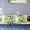 Letto con cuscini geometrici colorati in una stanza con pareti viola.