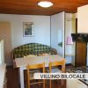 Interno di un villino con tavolo, sedie e divano.