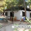 Villino esterno con veranda immersa nel verde.