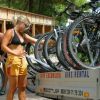 Una donna accanto a un rimorchio di noleggio biciclette.