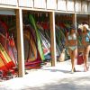 Due donne in bikini camminano davanti a vele colorate.