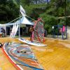 Tavole da windsurf su una piattaforma di legno, vicino a tende.