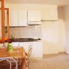 Cucina con tavolo apparecchiato e mobili bianchi.