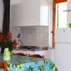 Cucina con tavolo coperto da una tovaglia colorata e fiori in vaso.