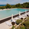 Piscina con lettini e vista mare.